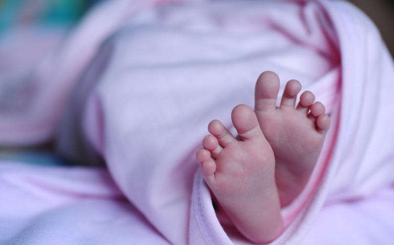 Can mother give adhan in the ear of newborn?